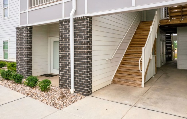 the front of a house with stairs and a sidewalk