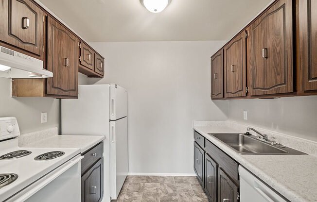 a kitchen with white appliances and wooden cabinets