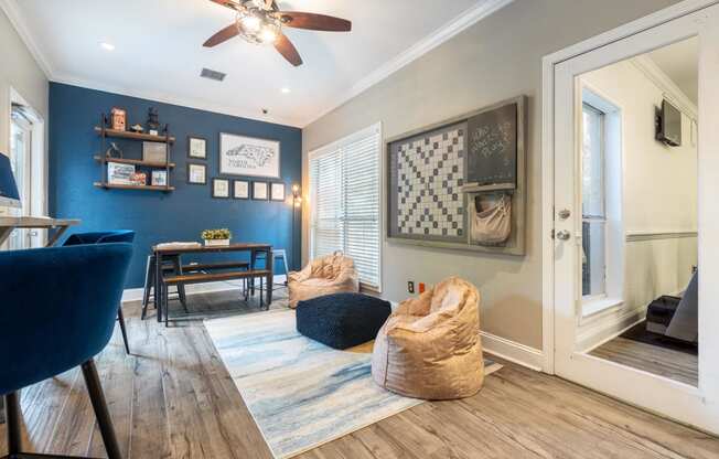 a living room with chairs and a ceiling fan