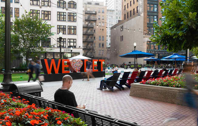 a man sitting on a bench in a park