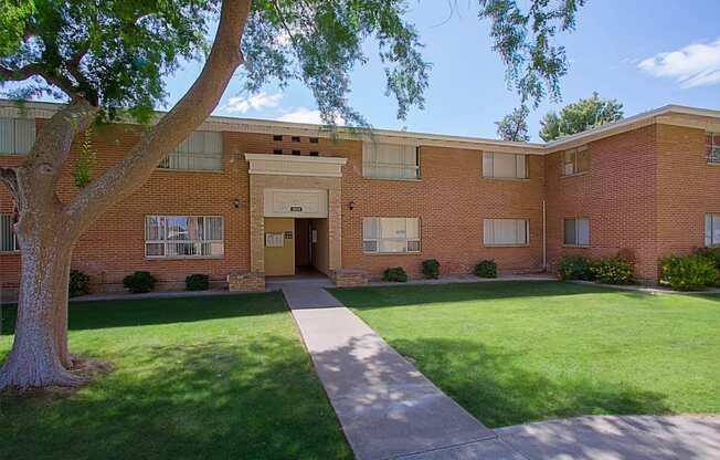 a large brick building with a lawn in front of it