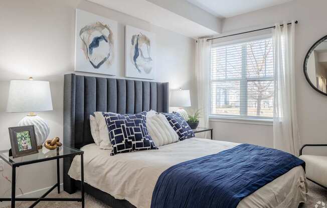 A bedroom with a bed, nightstand, and two wall art pieces.