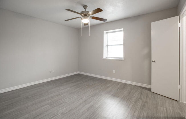 A room with a ceiling fan and a window.