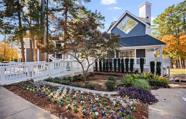 A white house with a blue roof and a white picket fence.