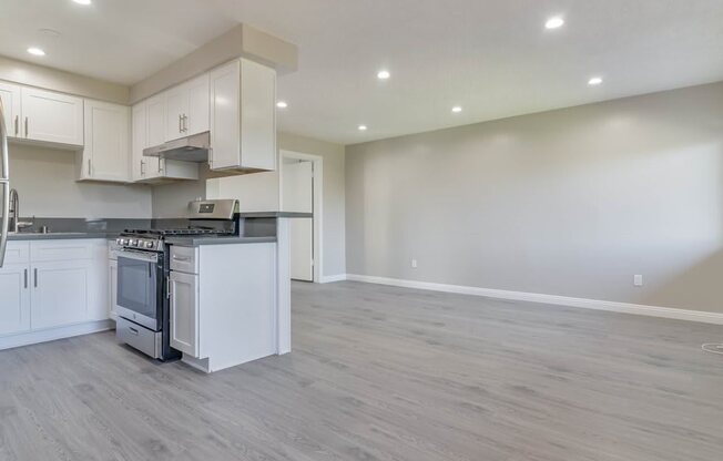 the kitchen and living room of a new home with white cabinets