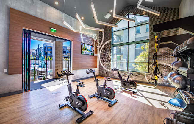 a gym with exercise bikes and a view of a building