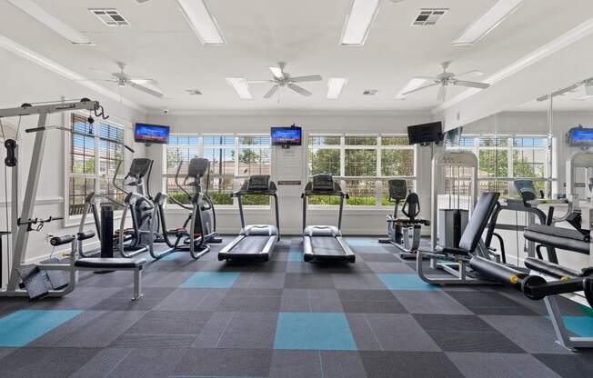 a large fitness room with treadmills and other exercise equipment