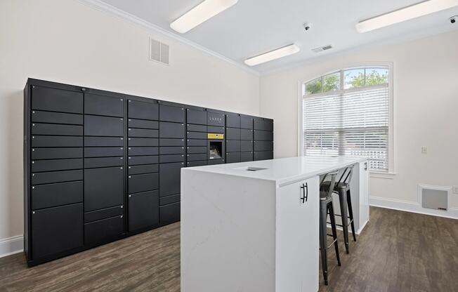 A kitchen with a white counter and black cabinets.