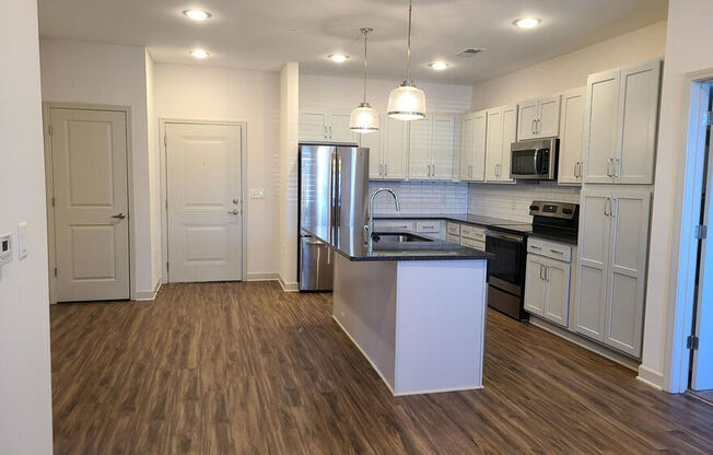 A kitchen with a white island and wooden floors.