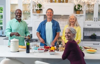 a group of people in a kitchen preparing food at The Falls of Portofino, Naples, FL