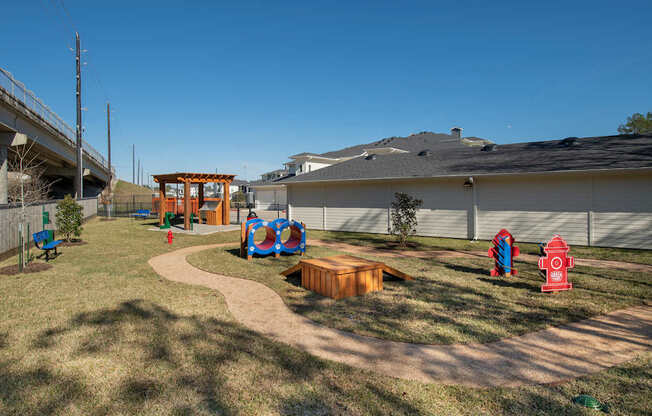A playground with a slide, swings, and a fire hydrant.