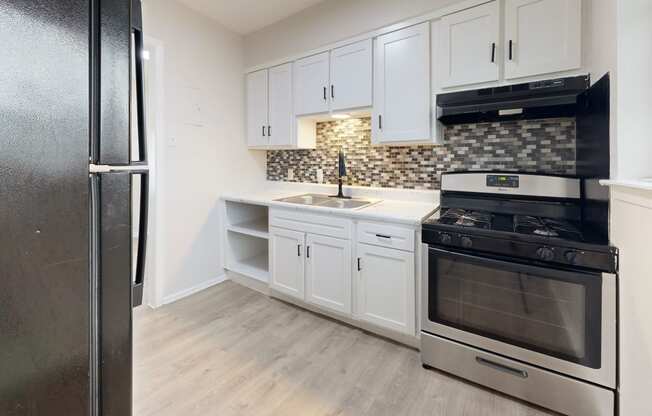 a kitchen with stainless steel appliances and white cabinets