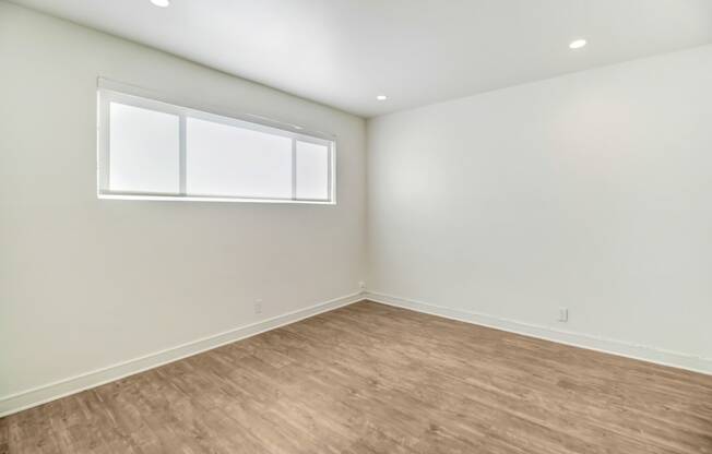 an empty room with white walls and a window