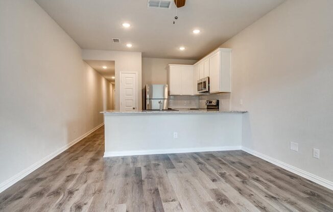the living room and kitchen of a new home with wood flooring
