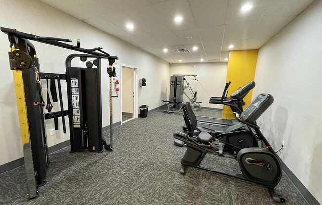 A gym with a row of exercise machines.