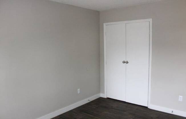an empty room with a door and a closet