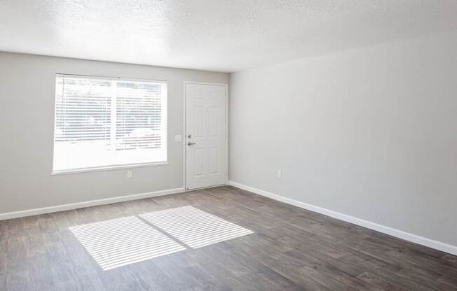 A room with a white door and a window with blinds.