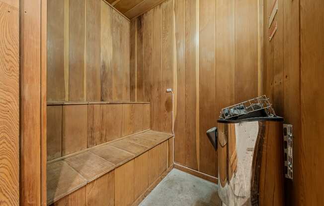 a wood paneled bathroom with a shower and a sink