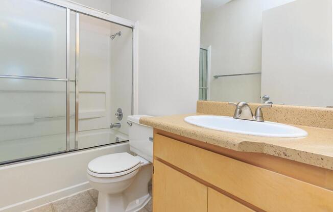 a white sink sitting next to a shower