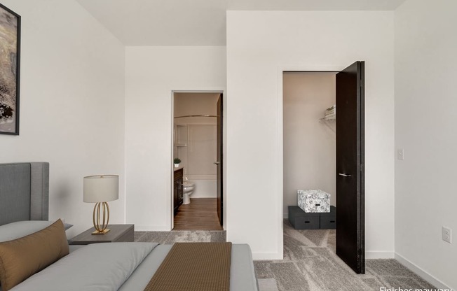 a bedroom with a bed and a door that leads to a bathroom