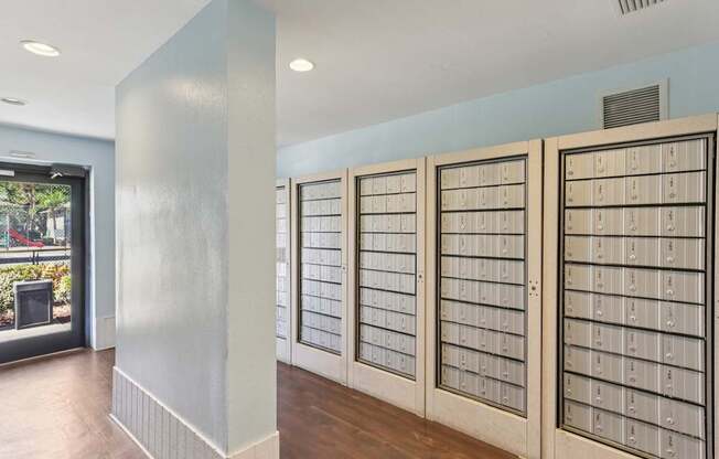 A room with a long row of mailboxes on the wall.