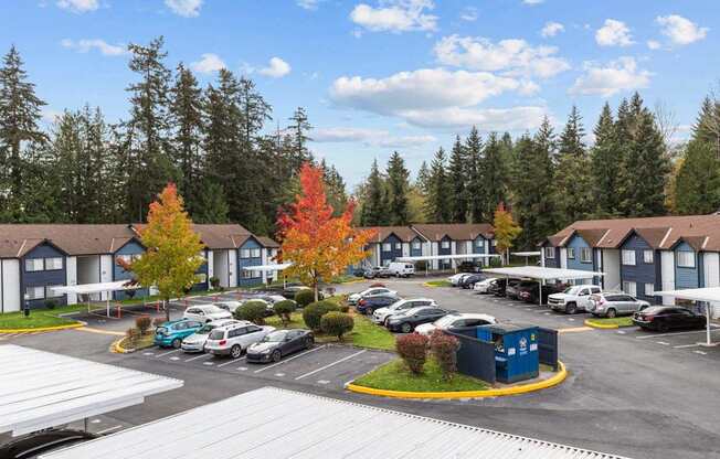 a parking lot filled with cars in front of houses
