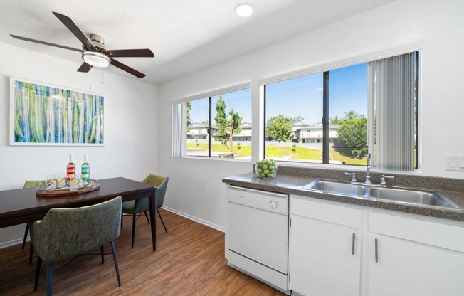 a kitchen and dining room with a large window and a ceiling fan
