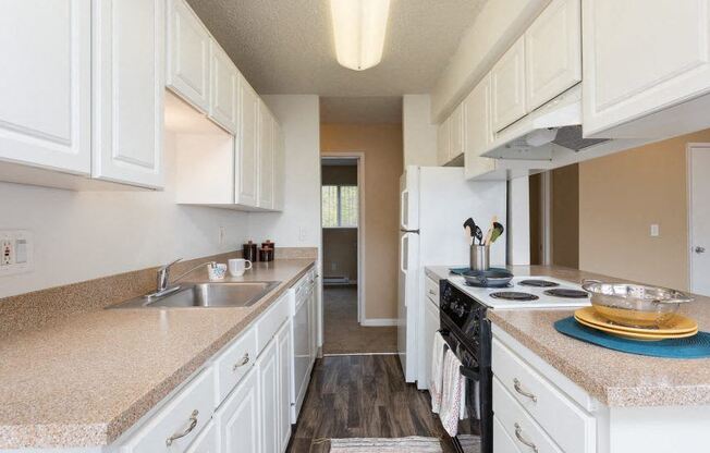 a kitchen with white cabinets and a stove and a sink