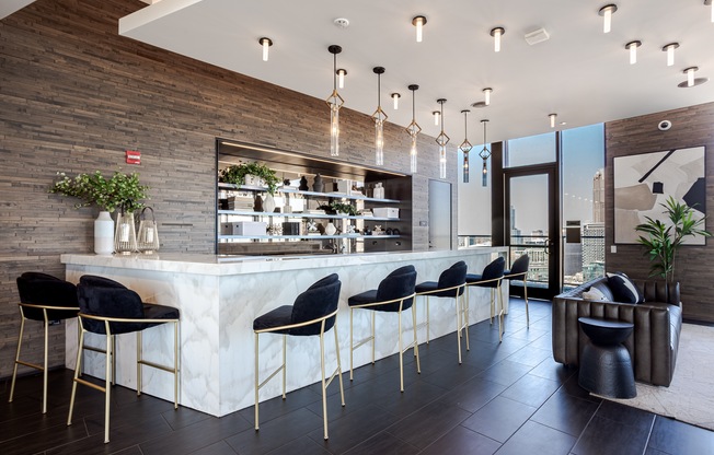 A modern bar with black chairs and a wooden wall.