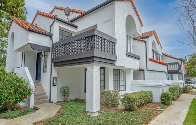 a white house with a balcony and a sidewalk  at The Resort at Encinitas Luxury Apartment Homes, Encinitas, 92024