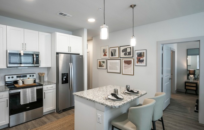 Indulge your culinary passions in style at Modera Georgetown's gourmet kitchen, featuring granite countertops, sleek shaker white cabinetry with satin pulls, and elegant under-cabinet lighting.