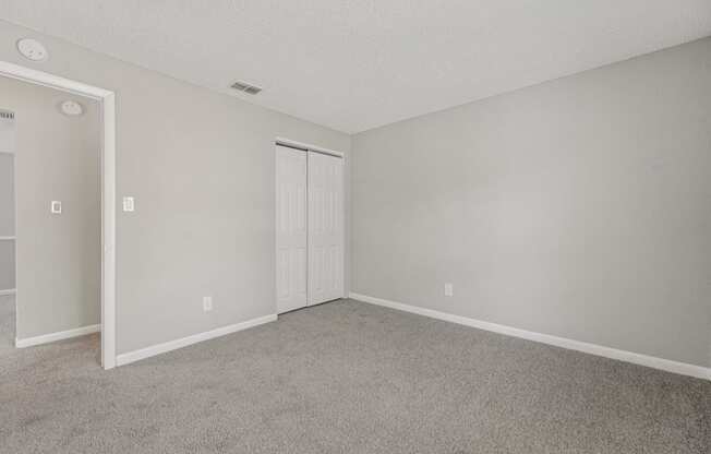 A room with a carpeted floor and a white door.
