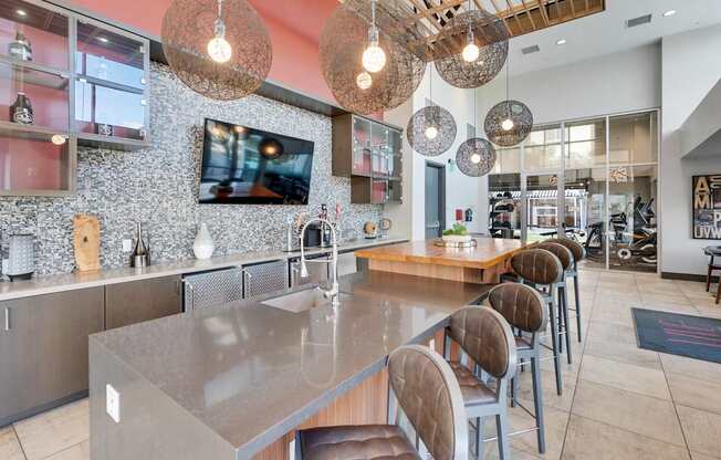A modern kitchen with a long island and chairs.