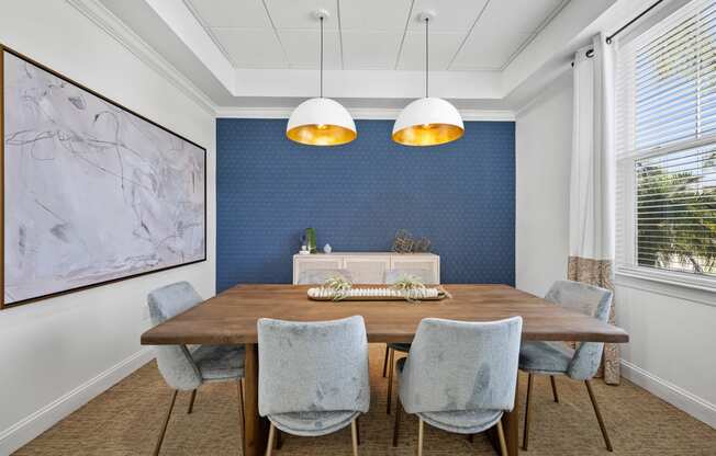 a dining room with blue wallpaper and a wooden table and chairs