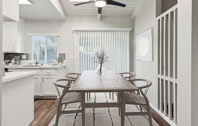 Model Dining Room and Kitchen Area with Wood-Style Flooring and Patio Accessibility at Colonnade at Fletcher Hills Apartments in El Cajon, CA.