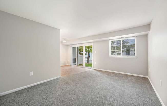 an empty living room with a window and a door to a yard at ReNew Odenton