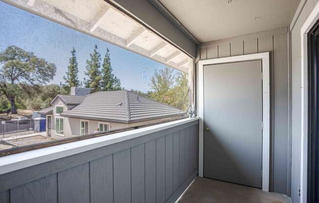 a balcony with a door and a view of a house