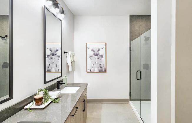 Quartz countertops, a double vanity, and a glass-enclosed shower bring ease and elegance to your private bathroom retreat.