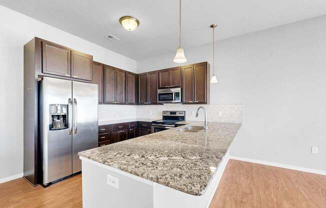 A kitchen with a granite countertop and stainless steel appliances.