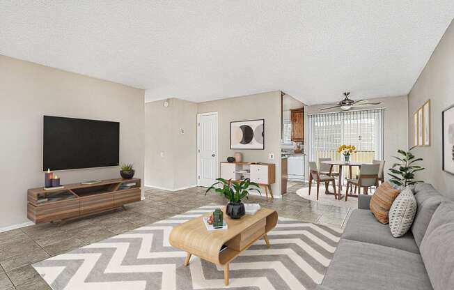 Apartment entrance leading into the living room with a large couch, coffee table and entertainment center with TV at Pacific Sands, San Diego, CA, 92117