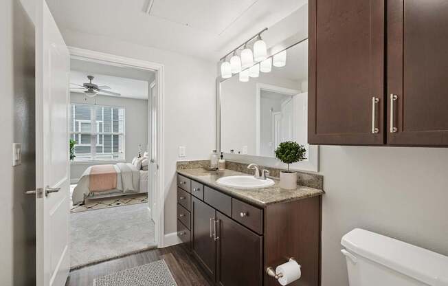 A bathroom with a brown vanity and a white bathtub.
