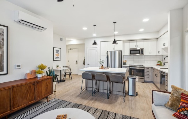 a living room with a kitchen and a table with chairs