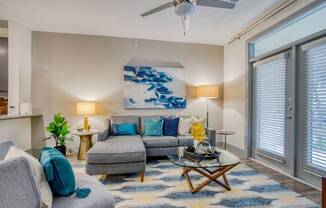 a living room with a couch and a ceiling fan at The Mark, San Antonio, TX