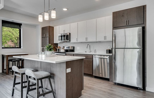 Kitchen with white cabinets, stainless steel appliances, and hanging lights over the island