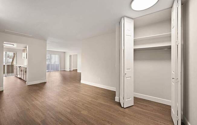 A large, empty room with wooden floors and white walls.