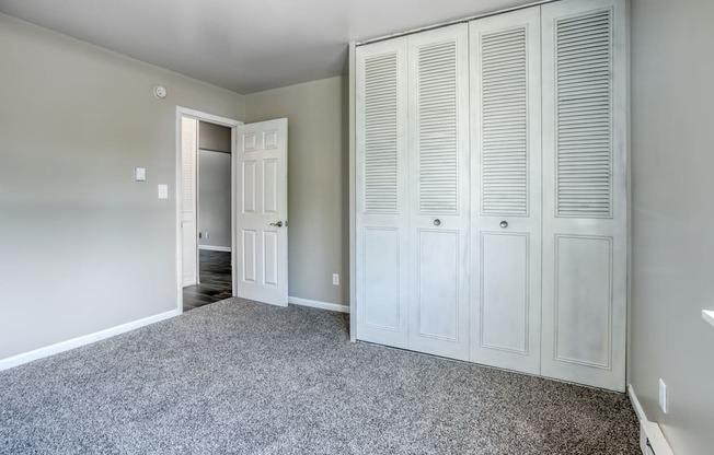 a bedroom with a closet and a door to a bathroom