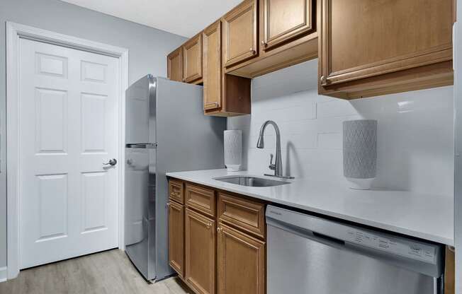 a kitchen with wooden cabinets and stainless steel appliances at Stonewater Apartments, Kentucky