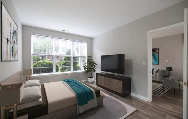 a bedroom with a bed and a tv in front of a window