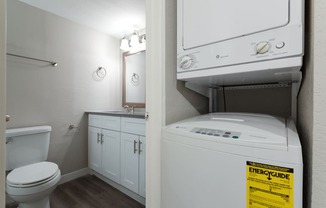 a bathroom with a washer and dryer and a toilet