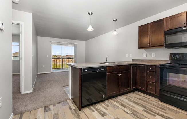 A kitchen with black appliances and wooden cabinets.